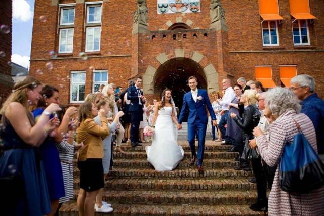 Erehaag gasten bellenblaas bruidspaar loopt trap af na bruiloft Raadhuis Leidschendam