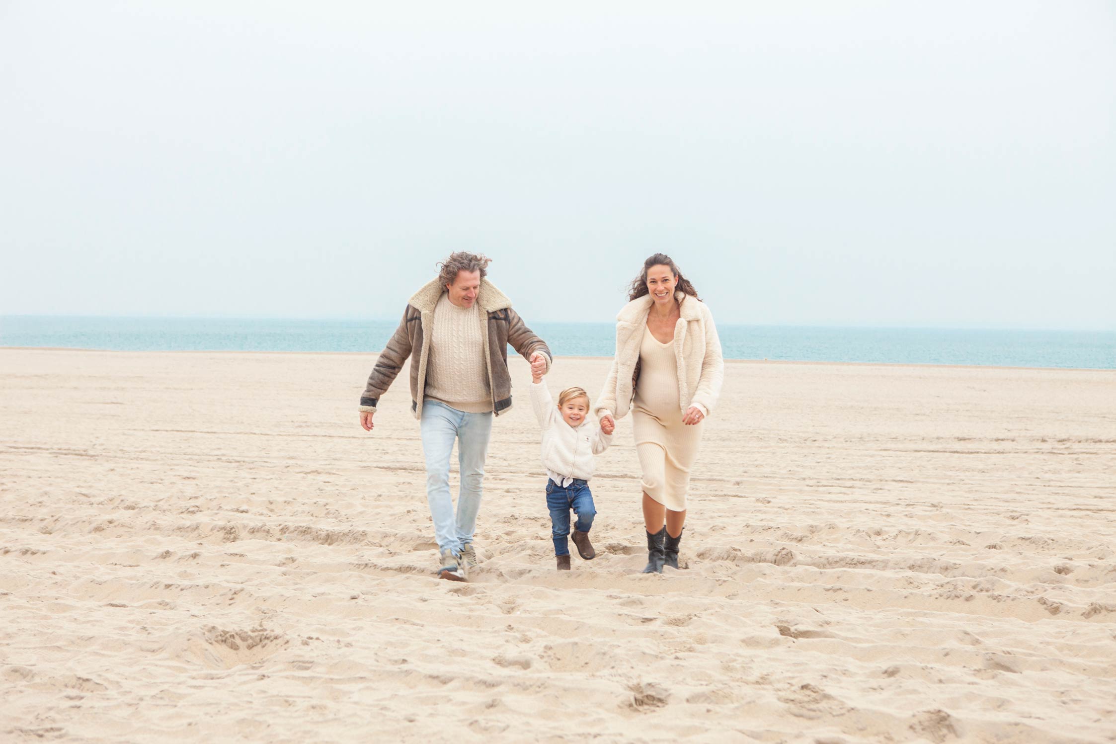 Vrolijke spontane familiefoto gezinsfoto familiefotografie gezinsfotografie strand fotograaf Irene Den Haag