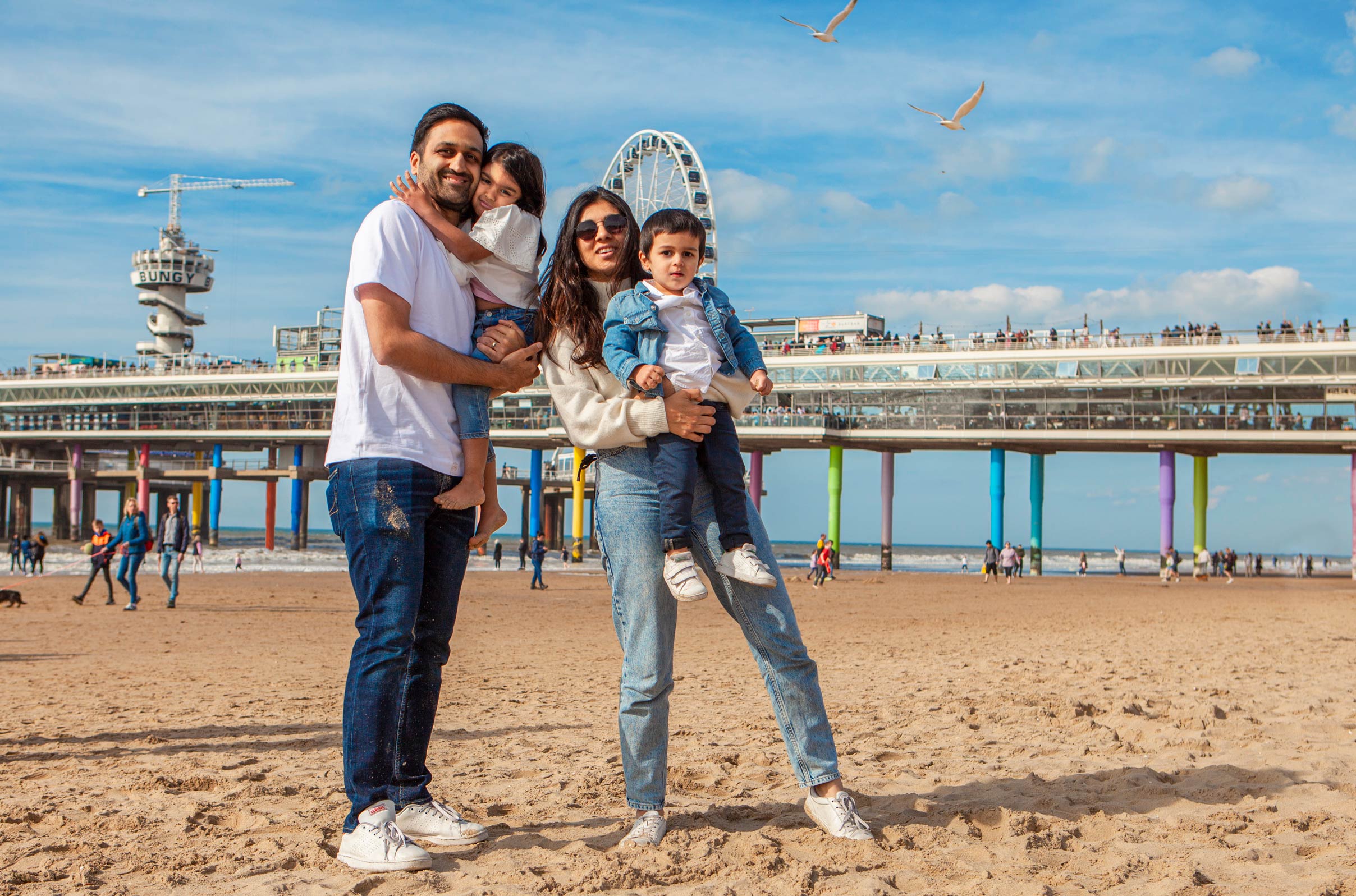Vrolijke ongedwongen spontane familie portret familiefoto gezinsfoto gezinsportret op locatie strand Scheveningen fotograaf Irene Den Haag