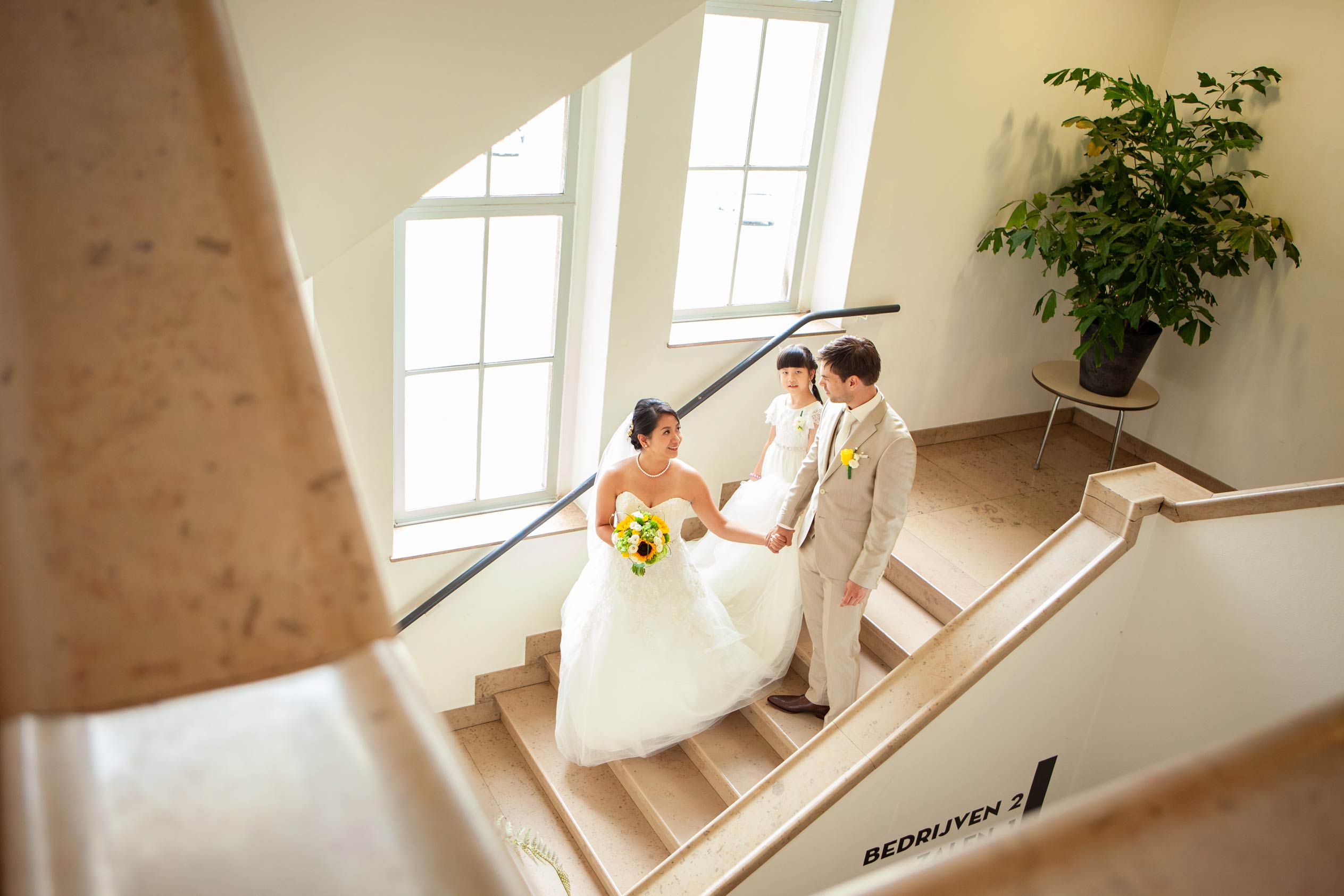Bruid loopt van trap in De Machinist Rotterdam trouwfoto vlak voor de ceremonie met bruidegom en bruidsmeisje trouwfotograaf Irene Den Haag Rotterdam