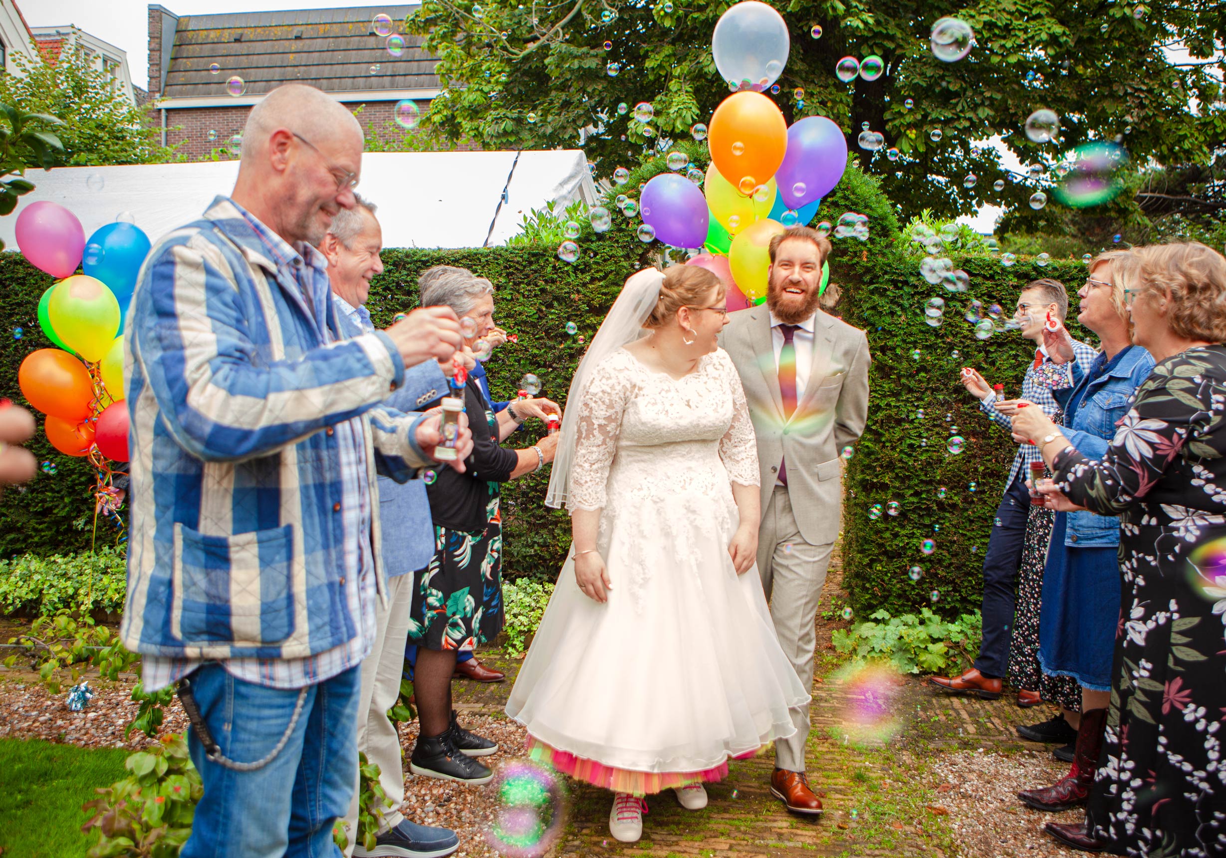 Vrolijke spontane trouwfoto bruidspaar erehaag met bellenblaas kleurrijke trouwfotograaf Irene Den Haag tuin der hesperiden Hofje van Wouw Den Haag