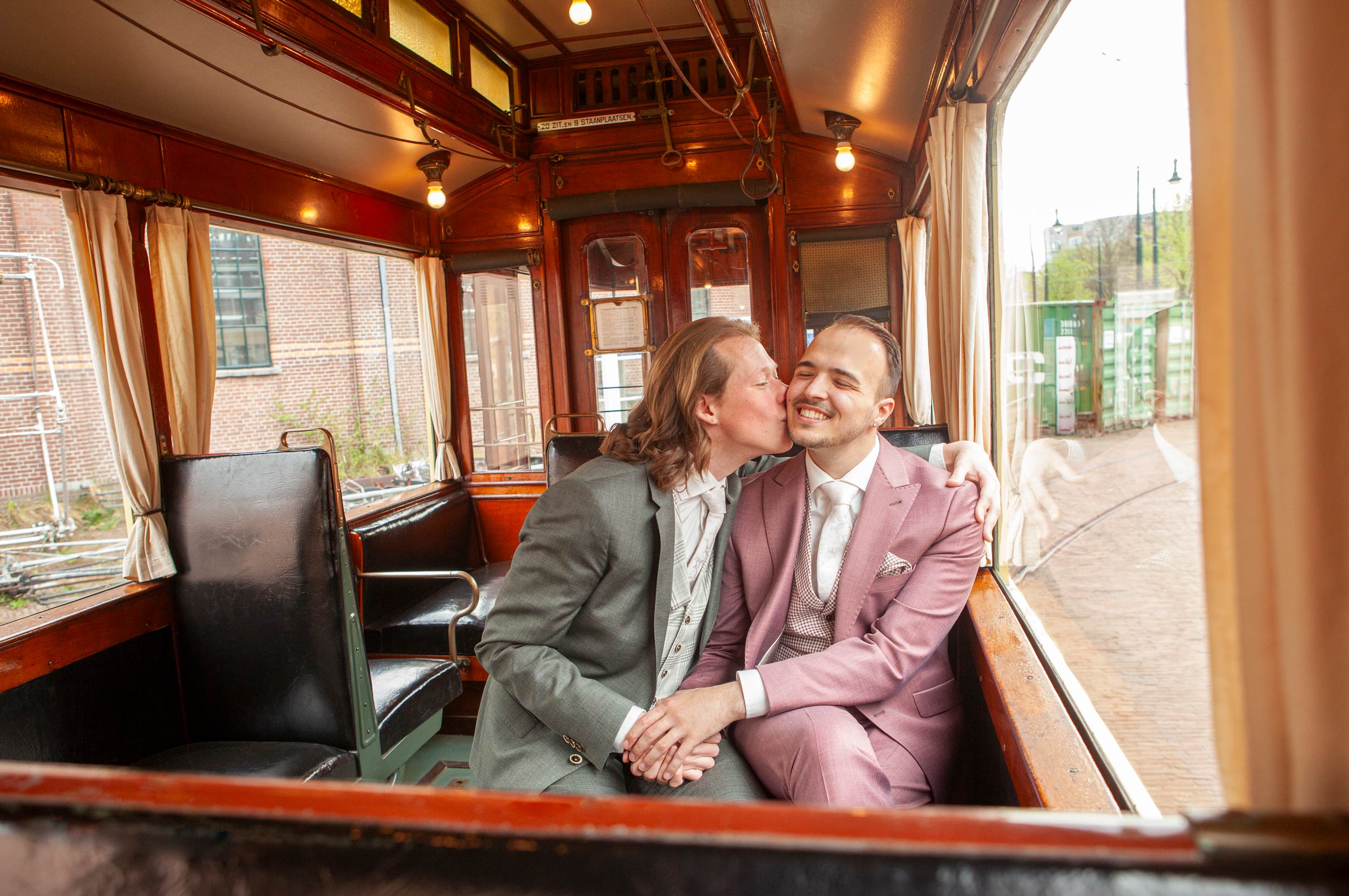 Romantische fotoshoot bruidspaar in hirstorische tram tramremise Den Haag regenboog huwelijk spontane trouwfotograaf Irene